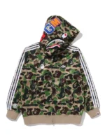 The front profile of the Bape x Adidas Camo Shark Full Zip Hoodie featuring the dual-branded logos and split shark face.