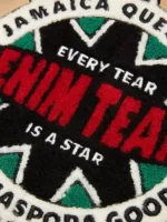 A close up view of the intricate star embroidery and fabric texture on the Denim Tears Tear Star Work Jacket.