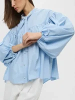 Side profile of the elegant Emma Sidi Baby Blue Blouse.