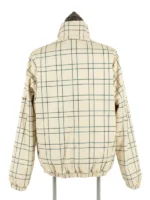 The back view of the beige and green checkered Masters Reversible Jacket on a mannequin stand, showcasing the continuous windowpane pattern across the shoulders and elastic waistband.