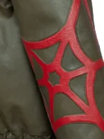 A detailed close-up shot of the forearm sleeve on the olive green Peter Parker Photographer jacket, showcasing the intricate red leather spider-web pattern stitched as an overlay.