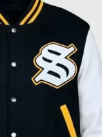 A detailed close-up of the fabric texture and embroidered logos on the Solflare Black and White Varsity Jacket.