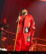 A full-length lifestyle shot of the Teddy Swims 3Arena Red Long Coat showcasing its dramatic drape and deep crimson shade.