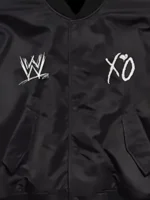 A detailed macro shot focusing on the premium fabric texture and hardware of the WWE x XO Bomber Jacket.