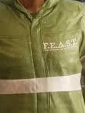 Close-up of F.E.A.S.T. chest logo with organization subtitle text white horizontal stripe and snap-tab zipper on green jacket