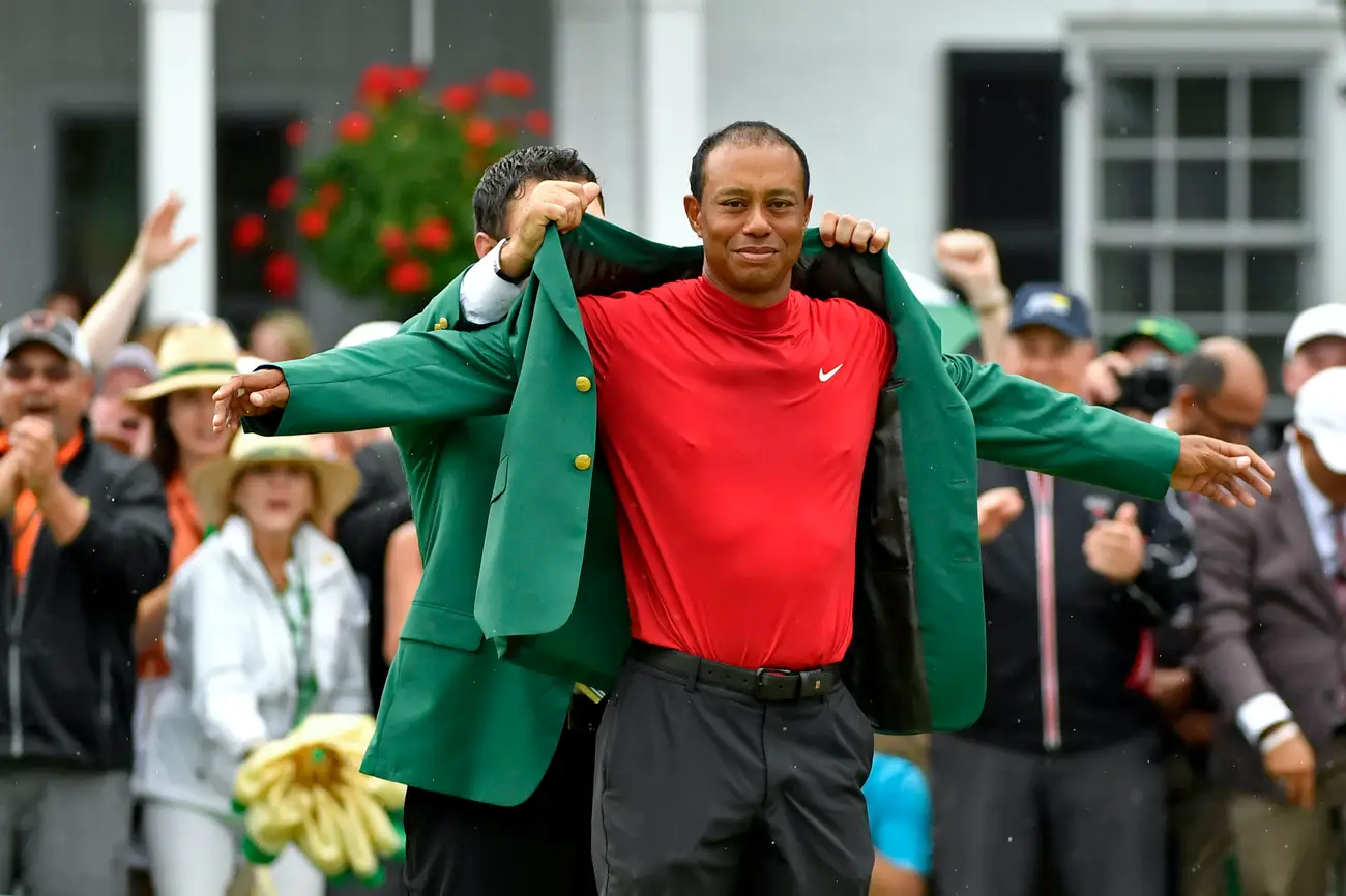 Golf champion arms wide open receiving the Masters green blazer during the Augusta National award ceremony