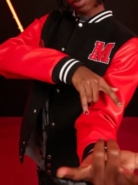 Close-up of Miles Morales varsity jacket M letter patch showing MILES text embroidered inside the red M with snap buttons and red leather sleeve visible