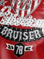 Close-up of American Bruiser rhinestone script and 78 banner badge on back of Pelle Pelle red leather jacket