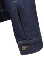 Detailed view of the buttoned cuff on the Triumph Jax denim jacket sleeve.