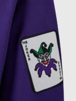 Close-up of embroidered Joker playing card patch on sleeve of OVO x The Joker 2026 purple pullover hoodie