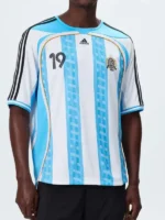 A premium standalone profile presentation of the blue and white striped Adidas x Kith Messi Football Jersey.