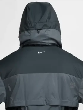Back hood detail of Nike ISPA Butterfly Jacket Anthracite Dark Grey showing structured hood buckle rear zip seam and Nike Swoosh on upper back