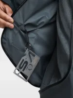 Open interior zip pocket of Nike ISPA Butterfly Jacket Anthracite showing mesh lining and metal ISPA multi-tool accessory on carabiner clip