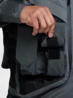 Hand repositioning velcro modular pocket on Nike ISPA Butterfly Jacket Anthracite against black hexagonal rubber grid panel with ISPA sleeve branding