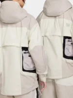 Back view of Nike ISPA Butterfly Jacket Natural Orewood Brown on male and female models showing rear modular pockets oversized silhouette and ISPA branding