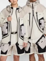 Nike ISPA Butterfly Jacket in Natural Light Orewood Brown colorway worn by male and female models showing full modular grid-shell pocket system and oversized fit