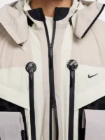 Nike ISPA Butterfly Jacket Orewood Brown front zip closure with dual ISPA circular logo badges and Nike Swoosh on chest close-up detail