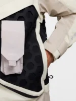 Single repositionable modular pocket mounted on black hexagonal rubber grid panel of Nike ISPA Butterfly Jacket in Natural Orewood Brown