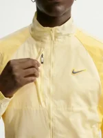 Front view of NOCTA Northstar Yellow Track Jacket with stand collar, zipper closure, and yellow polyester fabric