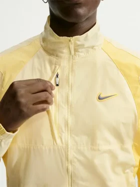 Front view of NOCTA Northstar Yellow Track Jacket with stand collar, zipper closure, and yellow polyester fabric
