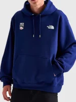 Front view of the blue The North Face x US Ski and Snowboard Hoodie with team logos.