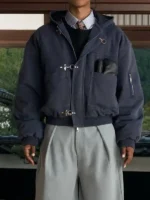 Model facing camera wearing navy Shinzo Shige canvas clasp bomber jacket paired with grey trousers