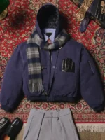 Navy Shinzo Shige canvas clasp bomber jacket with plaid scarf on ornate patterned editorial background