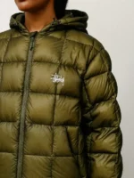 Close-up view of olive Stüssy Midweight Hooded Puffer Jacket with quilted nylon texture