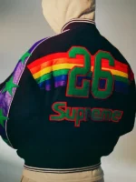 Back view of Supreme x Mitchell & Ness Denver Nuggets black varsity jacket showing number 26 in green and Supreme script above rainbow stripe