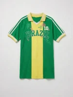 Clean studio flat-lay of the green and yellow Brazil 10 Goal Tee showing the embroidered text, number 10, and floral graphics against a plain background.