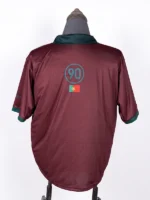 Rear view of the maroon CJ x Nike Portugal Total 90 Retro Jersey, featuring a central teal circle with the number 90 and the Portugal national flag beneath it.