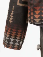 Close-up of a jacket sleeve featuring a vertical zipper at the cuff and a repeating geometric pattern of orange, brown, and gray triangles.