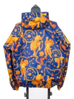 Full back view of the blue and orange FIFA World Cup 2026 Netherlands Anthem Jacket on a mannequin, displaying the repeating pattern of roaring lions, gold chains, and Dutch tulips.