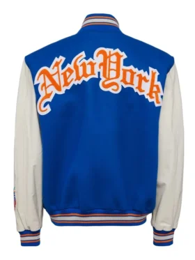 Rear view of the royal blue and cream New York Knicks varsity jacket highlighting the large arched gothic "New York" chenille patch across the shoulders.