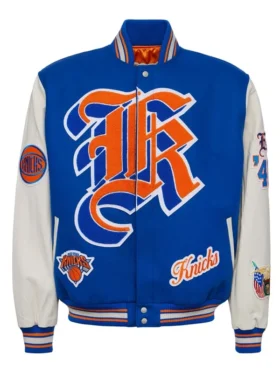 Front view of a royal blue and cream New York Knicks varsity jacket featuring bold gothic letter embroidery, team patches, and striped ribbed trim.