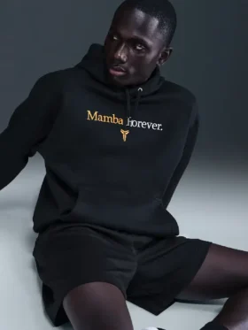 Kobe Mamba Forever Hoodie seated front view showing Mamba Forever University Gold text and Kobe Sheath logo graphic detail on black fleece