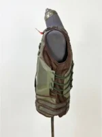 Profile side view of the Dark Knight Rises Bane tactical leather vest displayed on a mannequin, showcasing green side lacing and textured mesh fabric.