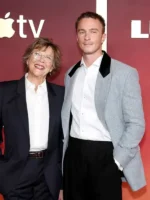 Man wearing the heather grey Drew Starkey premiere blazer with a white shirt and black trousers at a red carpet event.