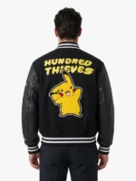 Male model wearing the black Pikachu Golden Bear varsity jacket, showing the large yellow Pikachu back patch.