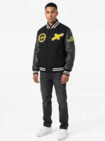 Male model wearing a black Pikachu varsity jacket with leather sleeves, yellow chest patches, and striped rib-knit trim.